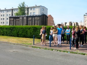 Groupe d'élèves pendant la visite guidée sur l'esplanade Charles de Gaulle, devant la Cité de la Muette de Drancy.
