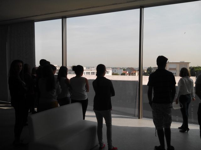 Mes élèves, dans la salle d’exposition permanente, observent les bâtiments de l’ancien camp que permet la façade transparente